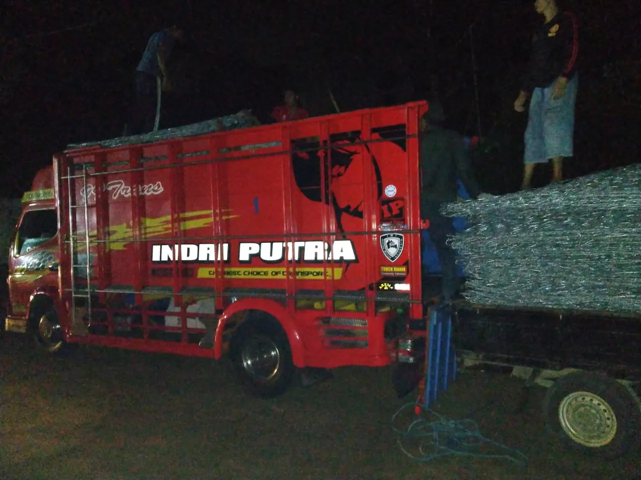 Truk merah memuat box bronjong pada malam hari