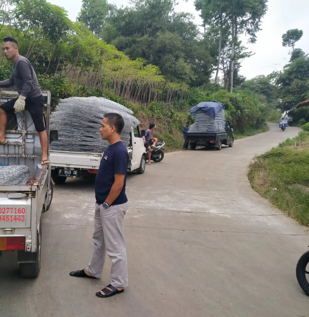 Mobil pick-up mengangkut bronjong kawat di jalan menanjak