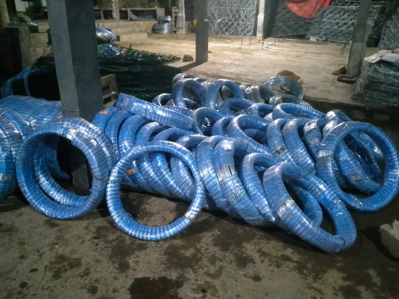 Gulungan kawat terbungkus plastik biru di area penyimpanan