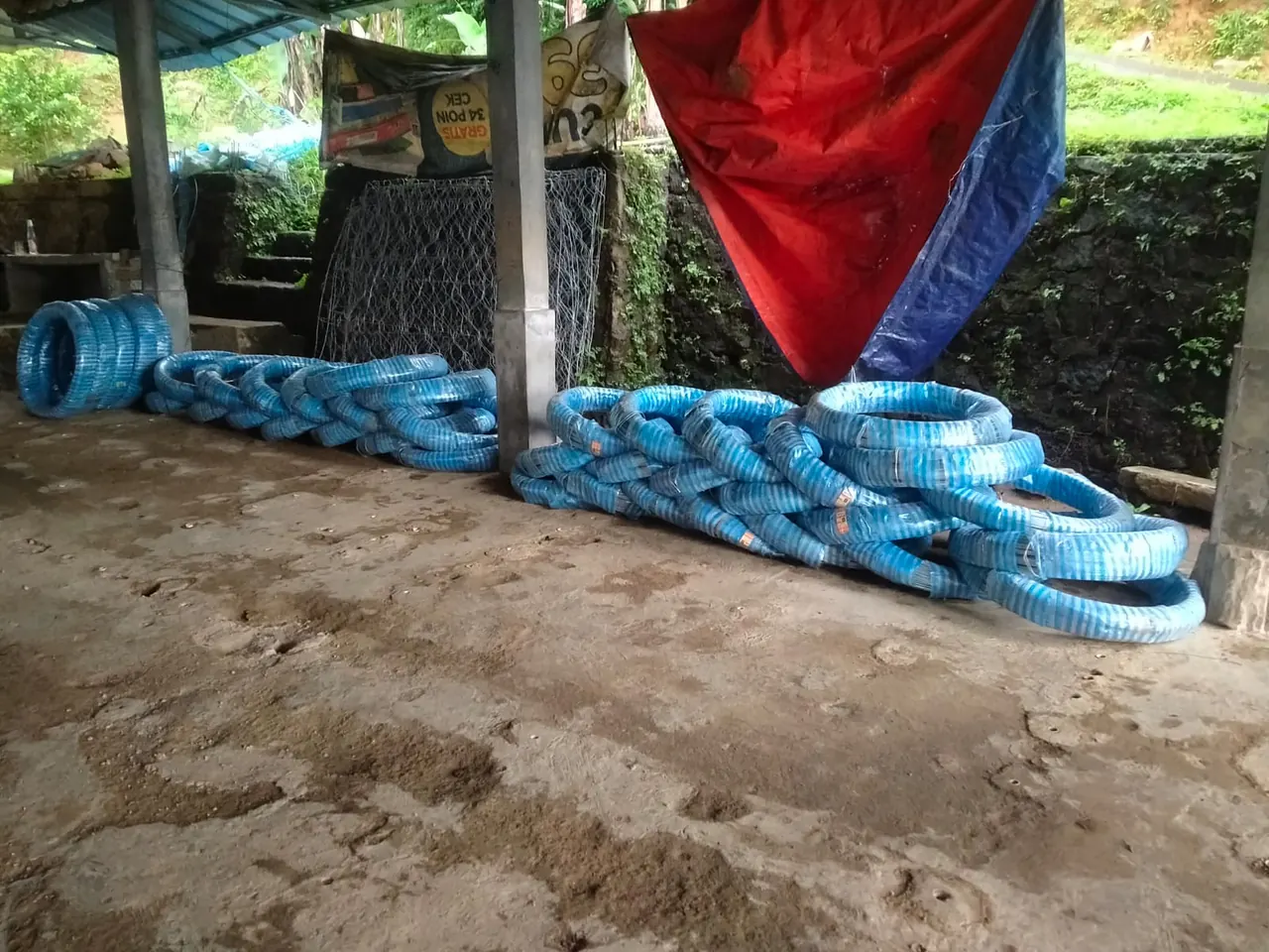 Gulungan kawat terbungkus plastik biru di gudang