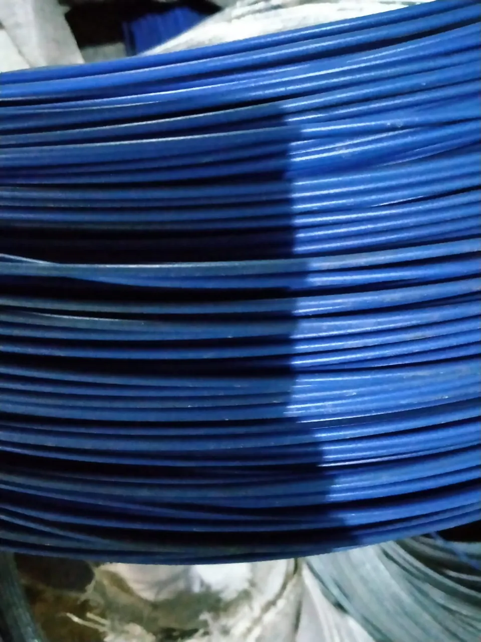 Kawat berlapis PVC biru tergulung rapat tampak dekat