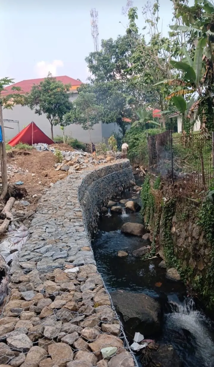Bronjong berisi batu sebagai pengaman saluran air di area permukiman